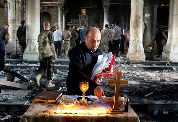 Irakilainen pappi valmistelee Qaraqoshissa ensimmäistä messua sen jälkeen, kun kaupunki ja kirkko on valloitettu takaisin Isisiltä. Kuva: LEHTIKUVA/REUTERS Ahmed Jadallah