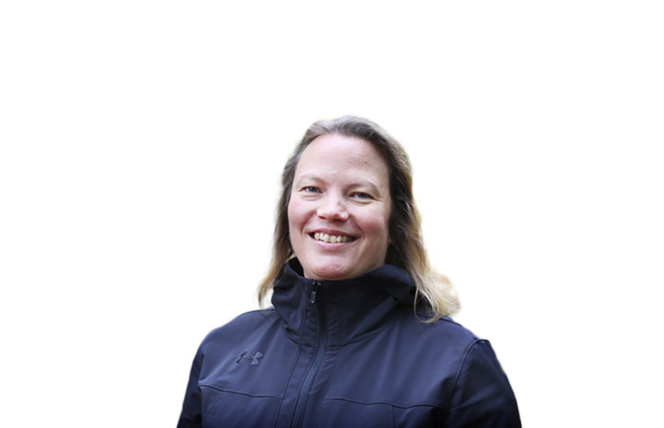 Tiina Karlsson hymyilee leveästi hiukset avoinna ja takki yllään.