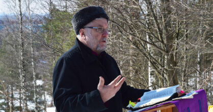 Aarre Kuukauppi saarnaa ulkona.