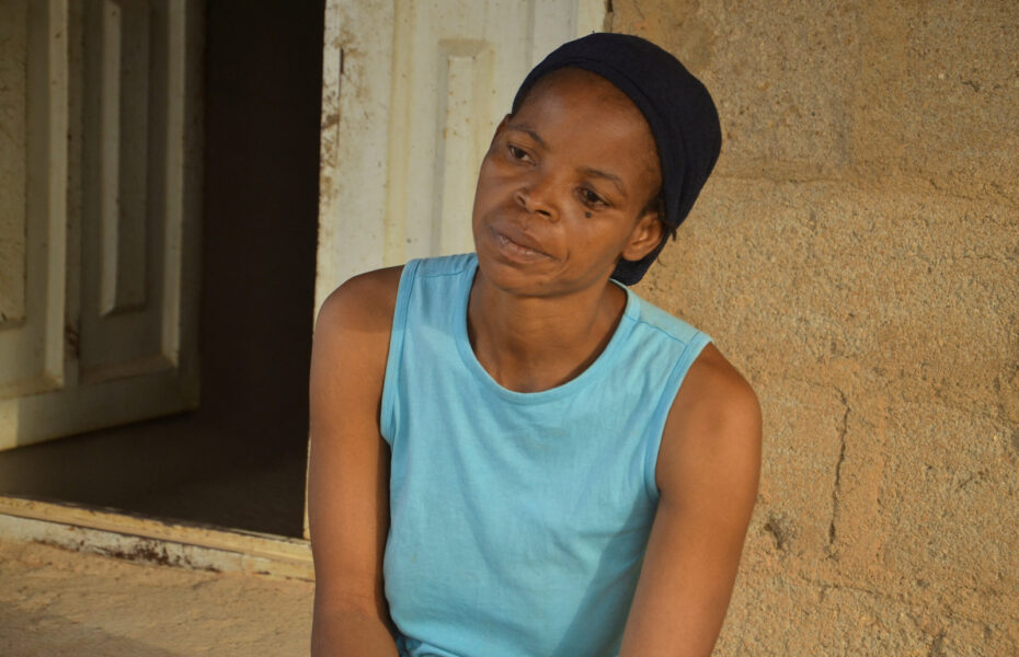 Turkoosissa paidassa oleva nainen katselee eteensä surullisen näköisenä