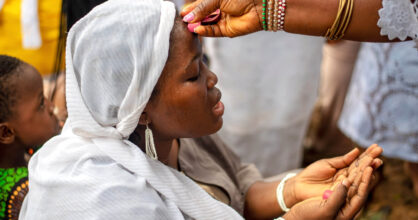 Afrikkalaisen naisen otsaa sivellään vedellä.