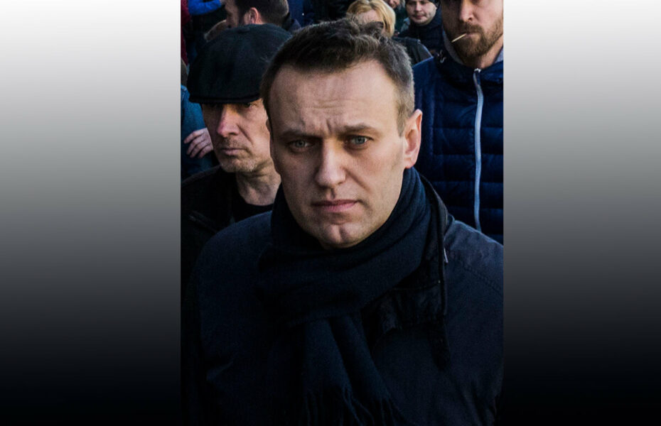 Aleksei Navalnyi väkijoukko takanaan, katsoo vakavailmeisenä eteenpäin.