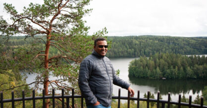 Alemayehu Kebede seisoo näköalatasanteella. Takana suomalainen mäntymetsä ja järvi.