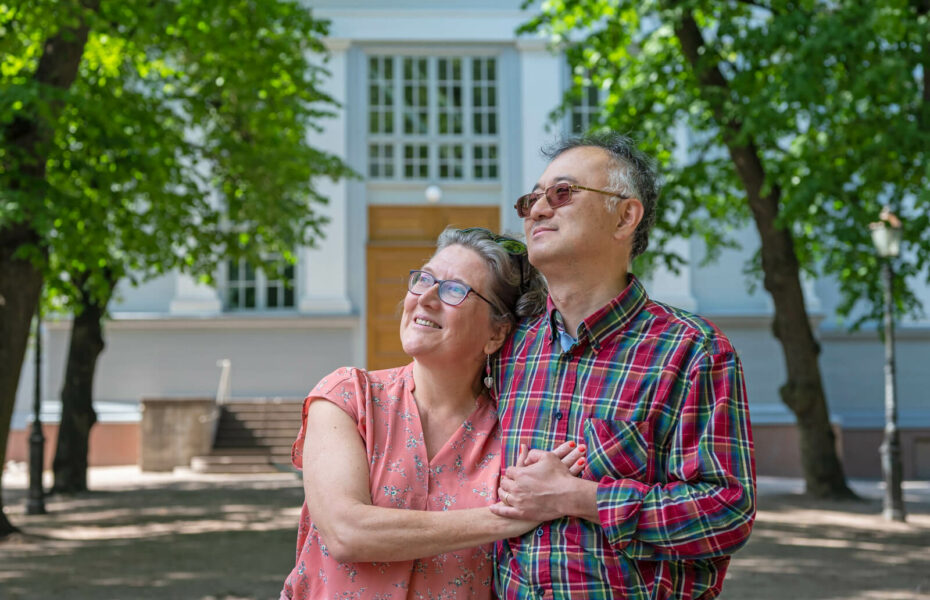 Kuvassa Anna-Kaisa ja Ken Takaki ovat sylikkäin Helsingin kadulla ja katselevat hymyillen ylöspäin.