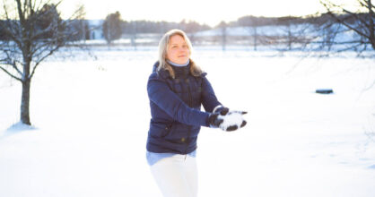 Anni on heittämäisillään lunta ilmaan.