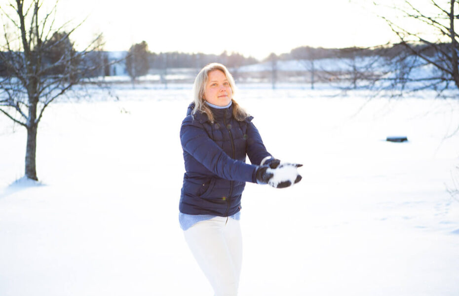 Anni on heittämäisillään lunta ilmaan.