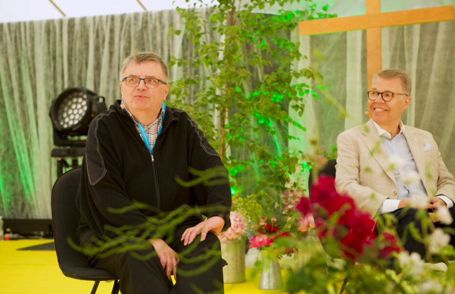 Antti Laato ja Risto huvila istuvat lavalla tuoleilla.