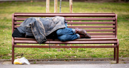 Koditon mies makaa puiston penkillä.