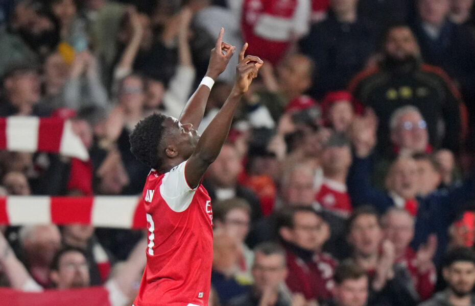 Jalkapalloilija Bukayo Saka on nostanut molemmat kätensä ilmaan.