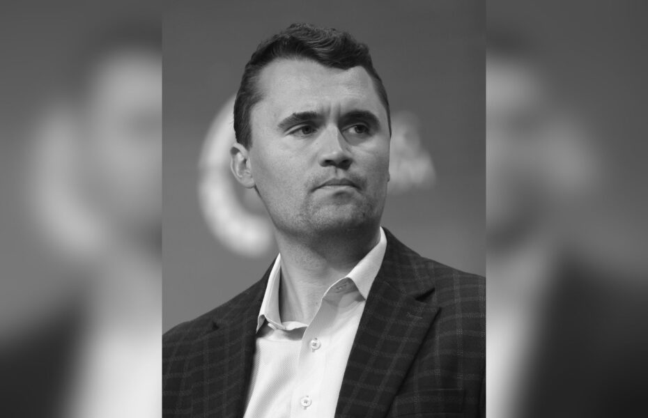Mustavalkoinen kuva miehestä, jolla on kauluspaita ja puvuntakki.