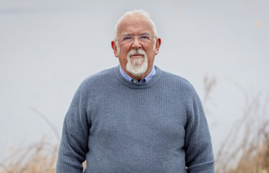 Clive Johnstonilla on silmälasit ja harmaantuneet hiukset ja parta.