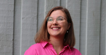 Elise Vilpas hymyilee. Hänellä on on puolipitkät hiukset ja silmälasit.