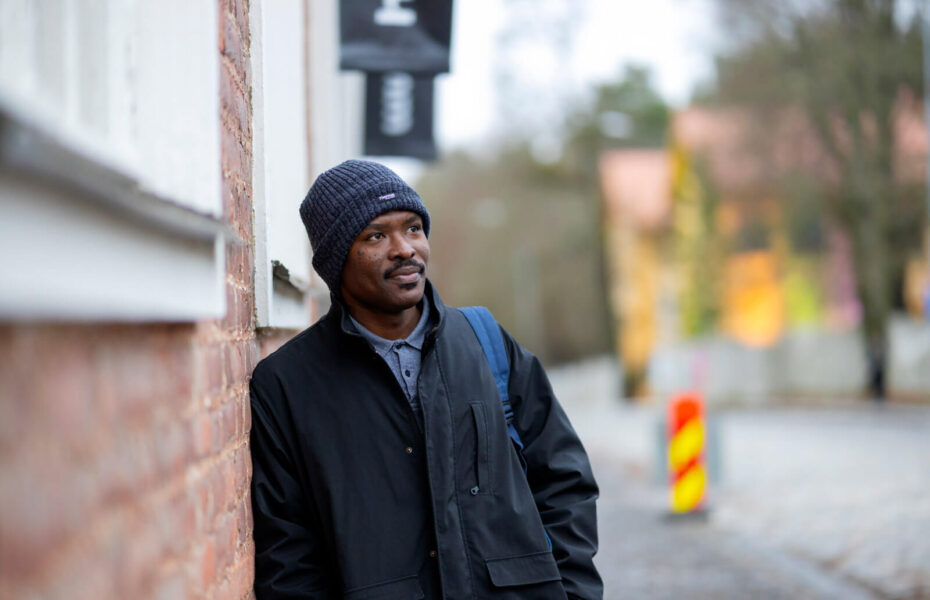 Emmanuel nojaa seinään.