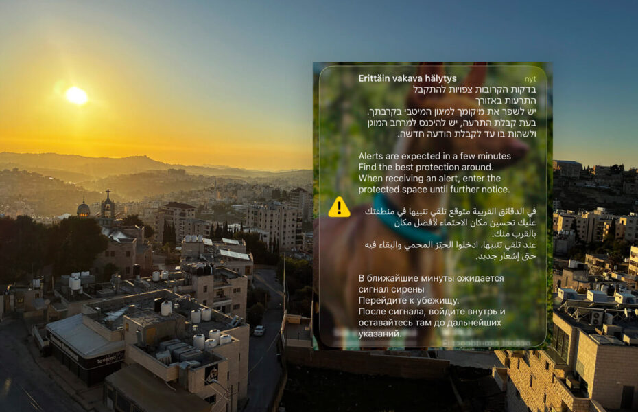 Maisema israelilaisesta kaupungista. Päällä kuvakaappaus kännykästä, jossa varoitetaan Iranin iskuista.