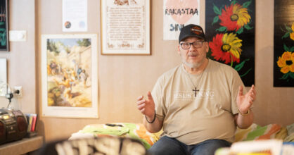 Mies istuu sängyn reunalla.