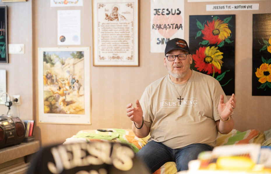 Mies istuu sängyn reunalla.