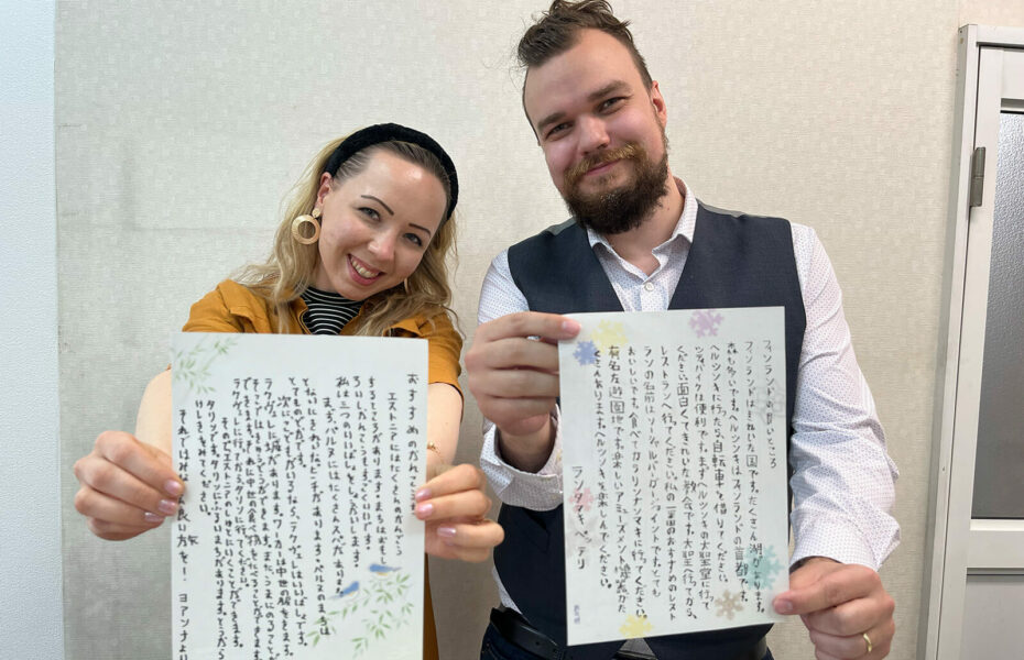 Joanna ja Petteri näyttävät papereita, joissa on japaninkielistä kirjoitusta.