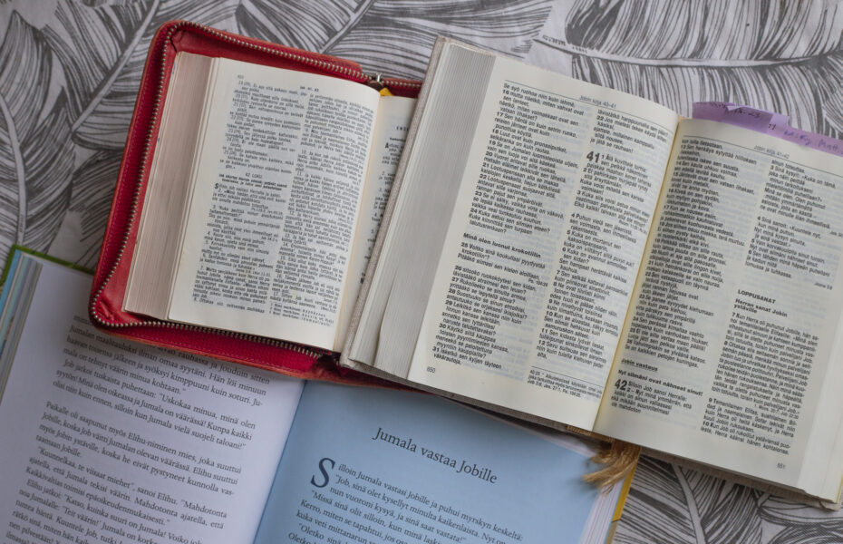 Kaksi Raamattua auki. Niiden alapuolella selitysteos Jobin kirjasta.