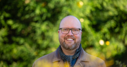 Johan Helkkula hymyilee. Hänellä on silmälasit.