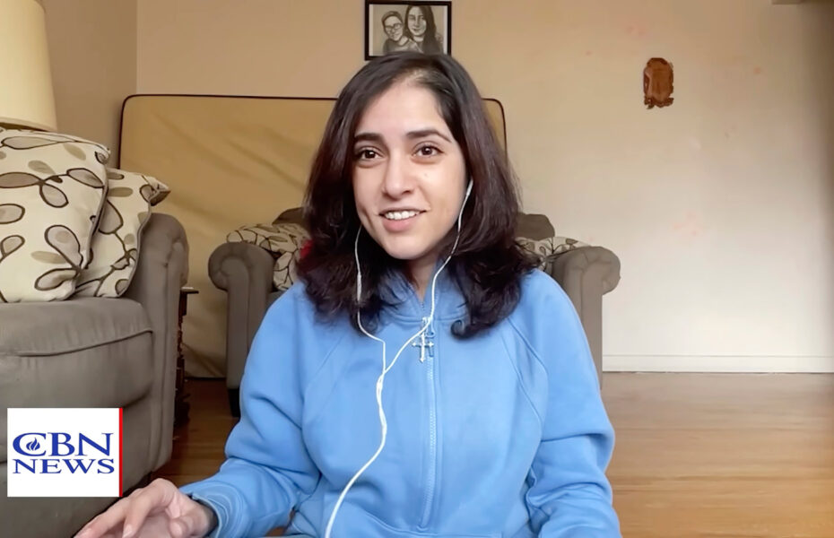 Nuori nainen sinisessä paidassaan ja kuulokkeet korvillaan