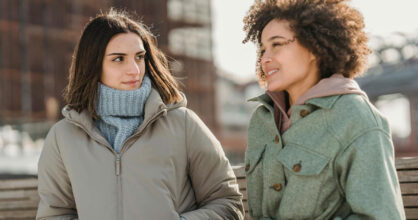 Kaksi naista ulkona keskustelee.