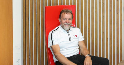 Kalle Sorsa istuu punaisella tuolilla paneeliseinän edessä.