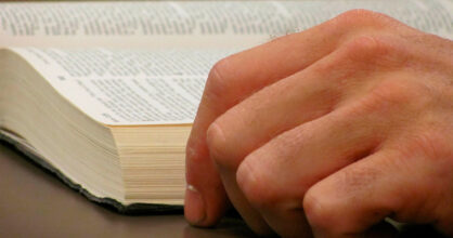 Miehen käsi ja Raamattu.