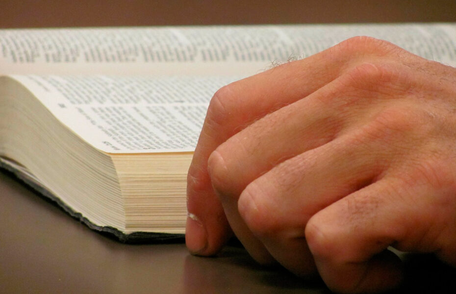 Miehen käsi ja Raamattu.