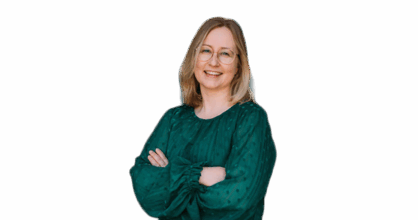 Nainen vihreässä paidassa hymyilee kädet puuskassa. Valkoinen tausta.