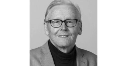 Mustavalkoinen kuva hymyilevästä Markku Huttusesta.