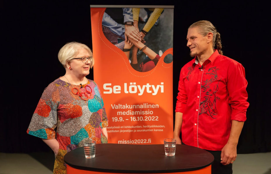 Anna-Maija Kalliokoski ja Toni Linjama seisovat pöydän ääressä, jonka takana mainoslakana, jossa lukee "Se löytyi".