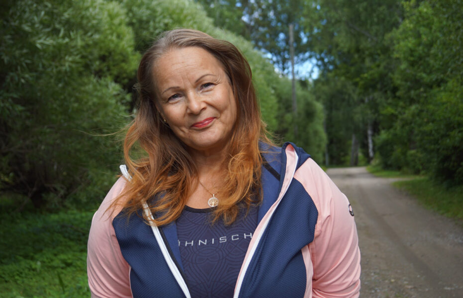 Mette-Maarit seisoo kadulla verkkatakissa.