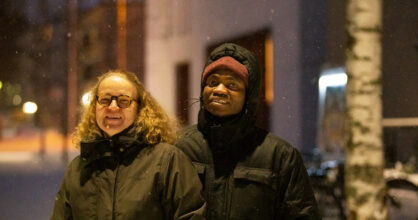 Leena ja Gerson Mgaya seisovat lumisella kadulla katulamppujen valossa.