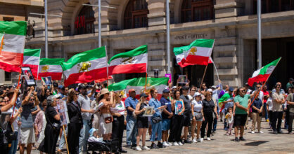 Mielenosoittajat heiluttavat Iranin lippuja.