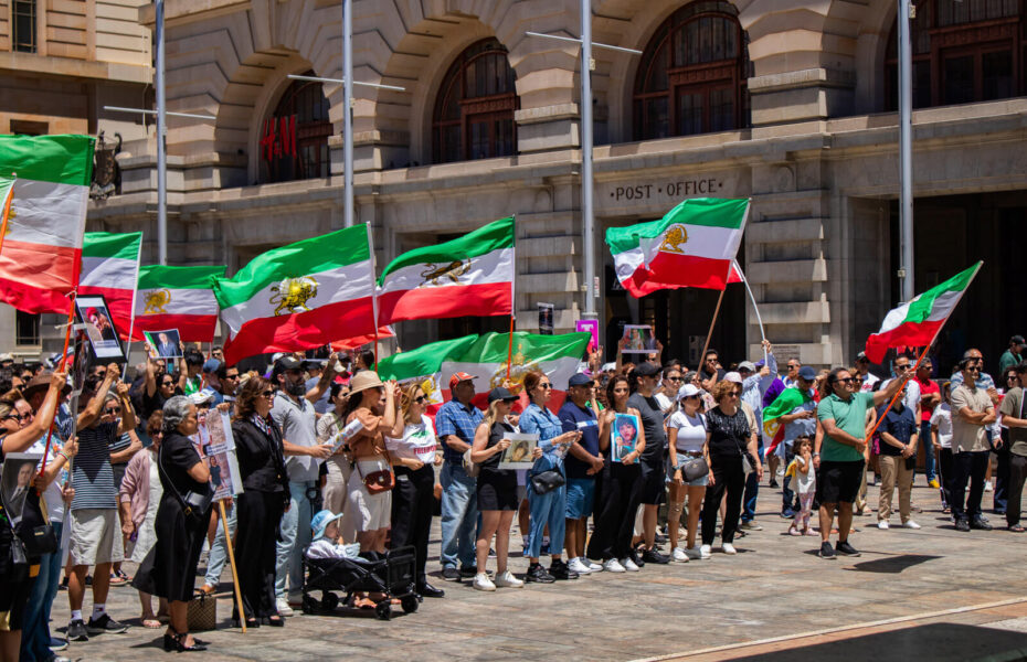 Mielenosoittajat heiluttavat Iranin lippuja.