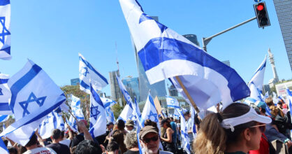 Joukko ihmisiä, jotka pitävät käsissään Israelin lippuja.