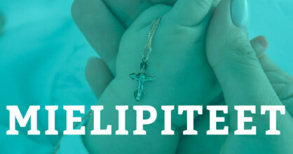 Vauvan kädessä on ristiriipus.