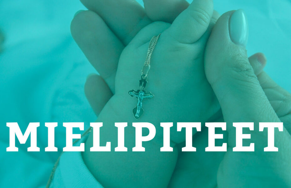 Vauvan kädessä on ristiriipus.