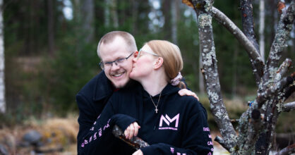 Nainen antaa suukon miehen poskelle.