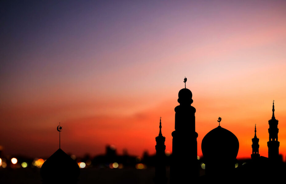 Kaupunki pimenevässä illalla. Torneissa näkyy islamin symboli puolikuu.