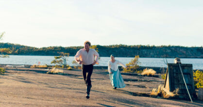 Janne ja Maija juoksevat peräkkäin kallioisella rannalla.