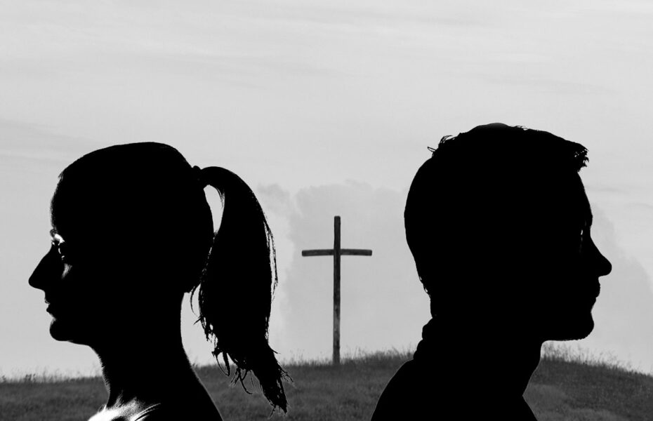 Mustavalkoinen kuva. Nainen ja mies katsovat eri suuntiin. Heidän välissään on risti.