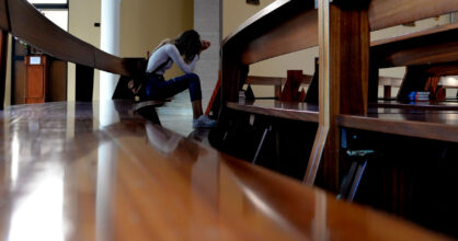 Nainen rukoilee kirkon penkissä.