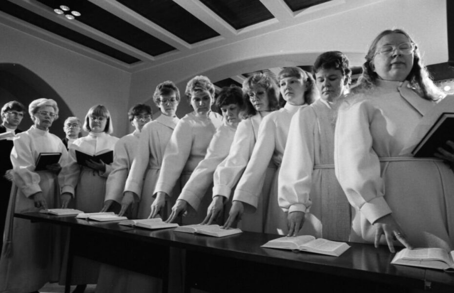 Mustavalkoinen kuva pappisvihkimyksestä, jossa on naisia.