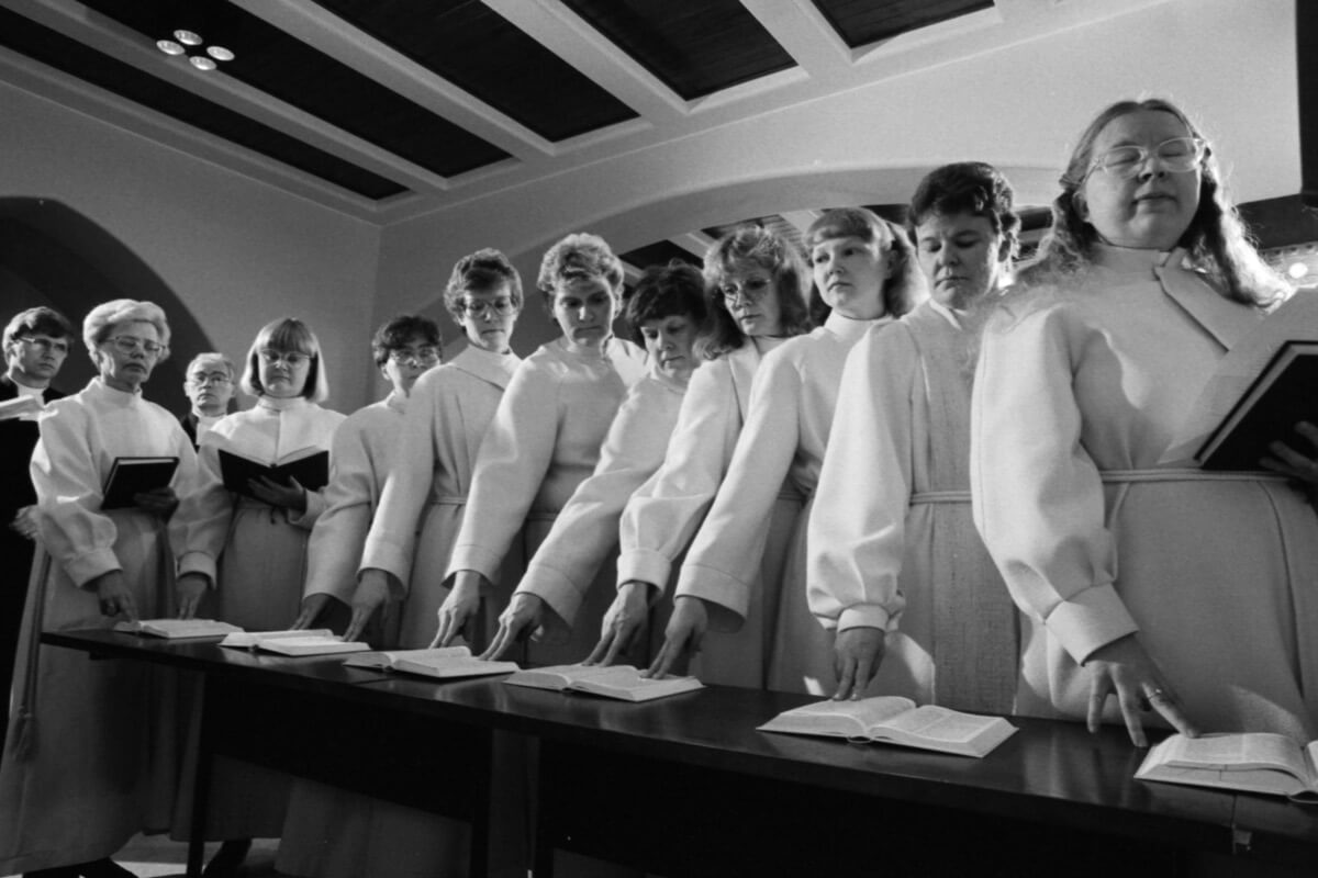 Mustavalkoinen kuva pappisvihkimyksestä, jossa on naisia. 