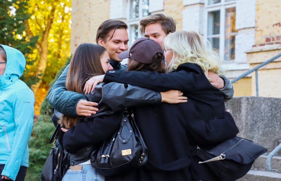 Joukko nuoria halaa toisiaan.