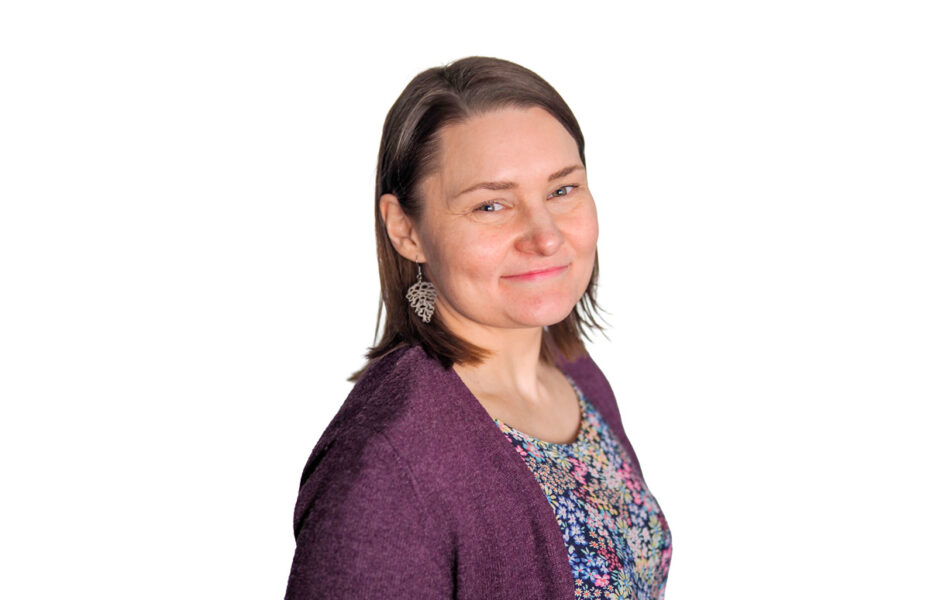 Pauliina Pylvänäinen hymyilee. Hänellä on hartioille ulottuvat ruskeat hiukset.