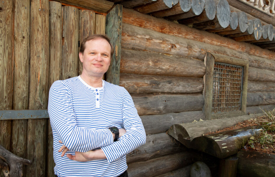 Petri Tuunainen nojaa hirsiseinään.