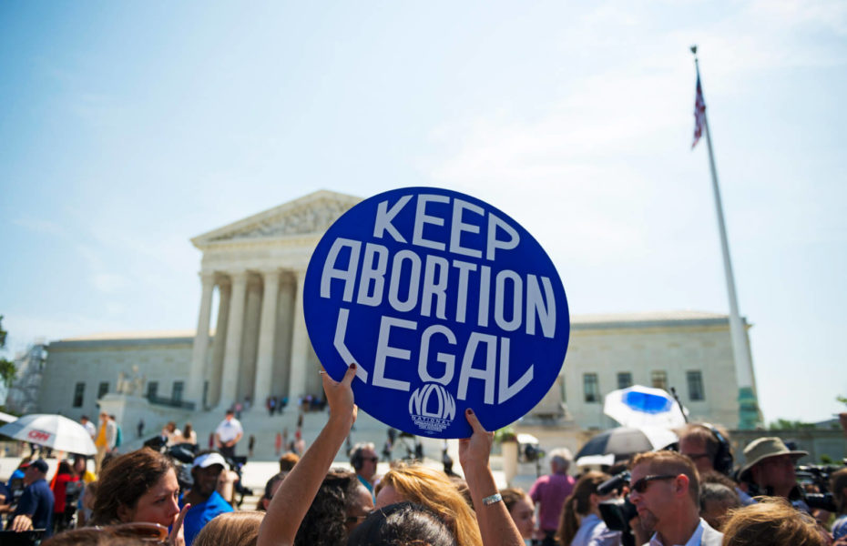 Väkijoukossa joku pitää ylhäällä kylttiä, jossa lukee "Keep abortion legal", eli pitäkää abortti laillisena.