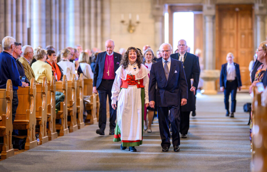Kirkon käytävää pitkin kävelee ihmisiä. Jonon ensimmäisenä on Ruotsin kuningas.